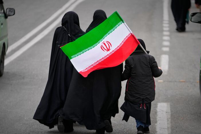 Two women and a child holding an Iranian flag walk toward the Imam Khomeini Grand Mosque to attend Friday prayers in Tehran, Iran, Friday, March 20, 2026. (AP Photo/Vahid Salemi)