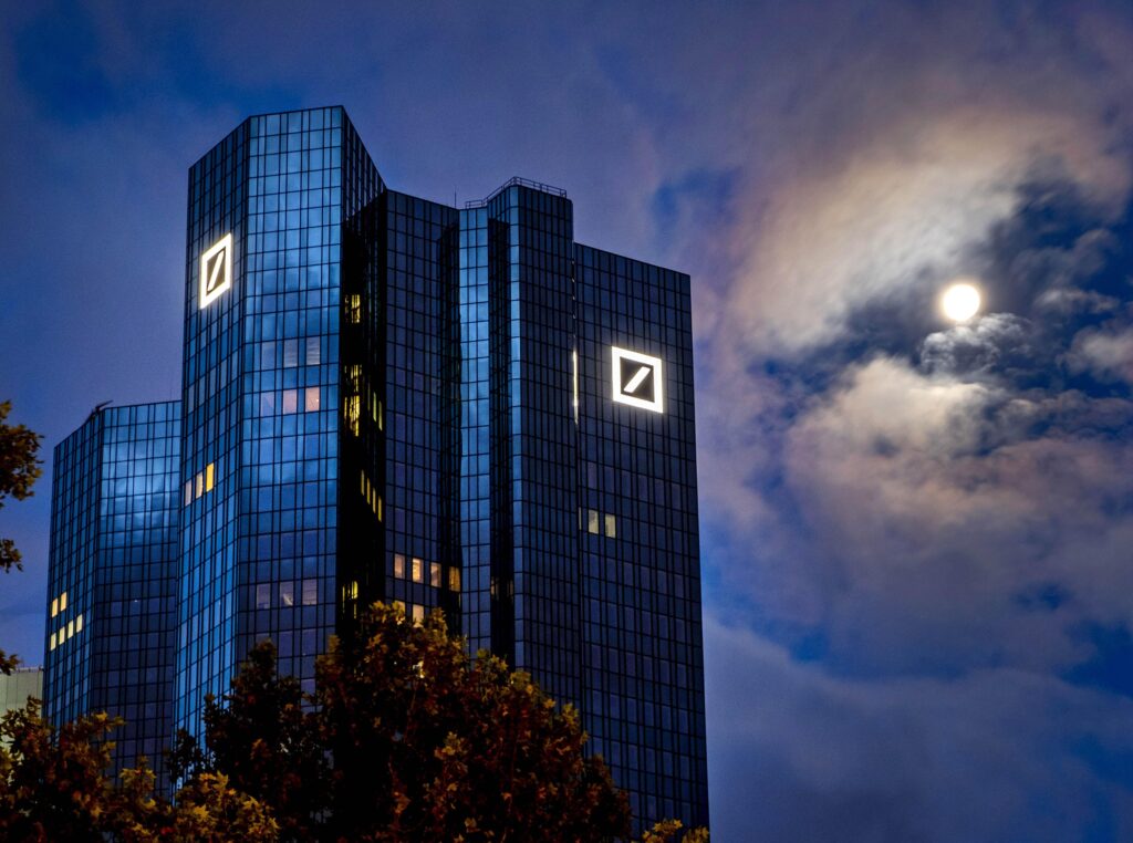 FILE — In this Oct. 4, 2020, file photo, the moon shines next to the headquarters of the Deutsche Bank in Frankfurt, Germany. Deutsche Bank releases first-quarter earnings on Wednesday. (AP Photo/Michael Probst, File)