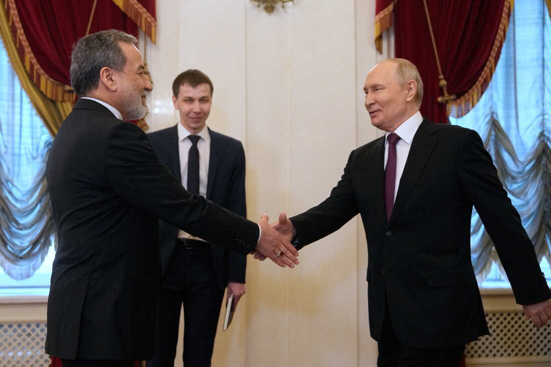 Russian President Vladimir Putin shakes hands with Iranian Foreign Minister Abbas Araghchi during their meeting at the Boris Yeltsin Presidential Library in Saint Petersburg on April 27, 2026. (Photo by Dmitry LOVETSKY / POOL / AFP)