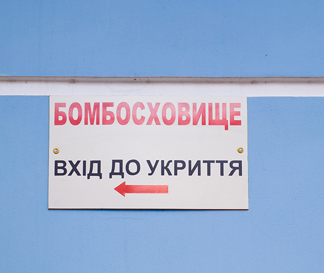 Signboard with inscription in Ukrainian - Bombproof Shelter. Refuge entrance. Air raid warning. Emergency sign. Russia-Ukraine War 2022.