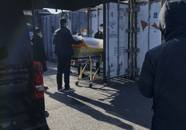 BEIJING, CHINA - DECEMBER 18: A coffin is loaded from a hearse into a storage container at the Dongjiao crematorium and funeral home, one of several in the city that handles COVID-19 cases, on December 18, 2022 in Beijing, China. China's capital has seen a surge in COVID-19 cases since the government lifted its strict zero tolerance measures to contain the virus earlier this month. (Photo by Getty Images)