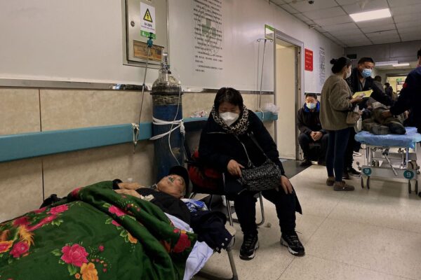 A patient with Covid-19 lays on a bed in a hallway at Tangshan Gongren Hospital in China's northeastern city of Tangshan on December 30, 2022. (Photo by Noel Celis / AFP) (Photo by NOEL CELIS/AFP via Getty Images)
