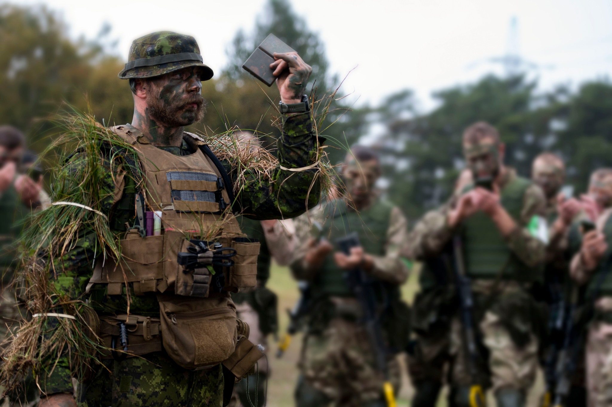 A Canadian Armed Forces soldier with 3rd Battalion, Princess Patricia's Canadian Light Infantry mentors Ukrainian recruits during a camouflage lesson during Operation UNIFIER-UK on 20 October 2022 in the United Kingdom.Please Credit: Corporal Eric Greico, Canadian Armed Forces Photo.  Image has been digitally altered for operational security purposes.