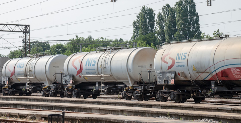 PANCEVO, SERBIA - MAY 19, 2018: Cistern Tank wagons train from Nafta Industria Srbije passing in an industrial district of Pancevo. NIS  is a Serbian multinational oil and gas companyPicture of Oil Wagons (tankers) from the Serbian branch of Gazprom, NIS, passing near a factory in an industrial environment of Pancevo, Serbia. Naftna Industrija Srbije, or NIS, is a Serbian multinational oil and gas company 