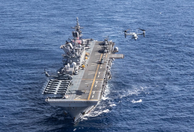 A U.S. Marine Corps MV-22B Osprey takes off from amphibious assault carrier USS Tripoli (LHA 7) as it sails in front of amphibious assault carrier USS America (LHA 6) during a photo exercise in the East China Sea, Sept. 17, 2022. This training evolution provided two America-class ships the opportunity to sail together in close proximity, providing valuable training to both crews. The 31st Marine Expeditionary Unit is operating aboard ships of the Tripoli Amphibious Ready Group in the 7th Fleet area of opera