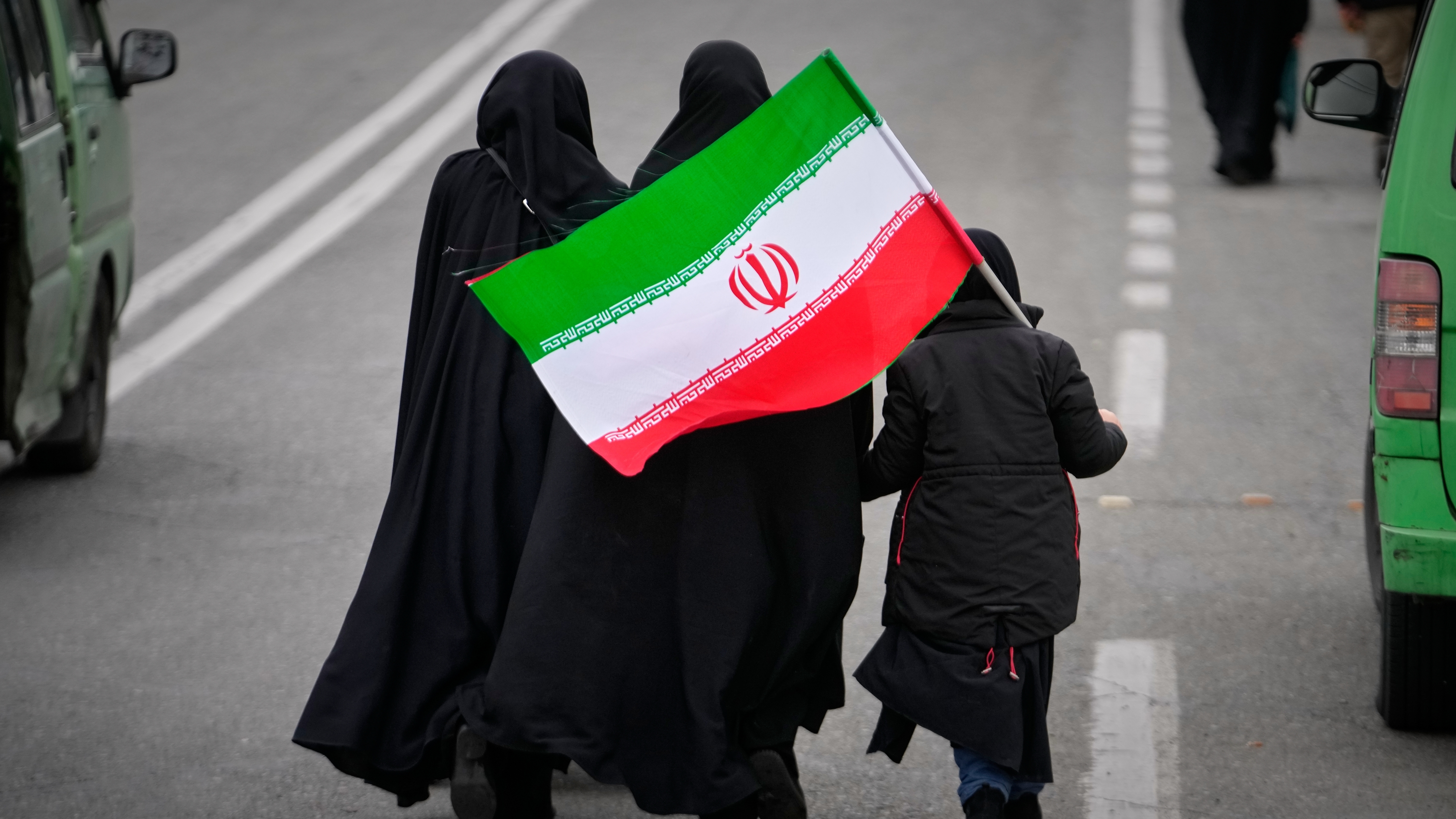 Two women and a child holding an Iranian flag walk toward the Imam Khomeini Grand Mosque to attend Friday prayers in Tehran, Iran, Friday, March 20, 2026. (AP Photo/Vahid Salemi)