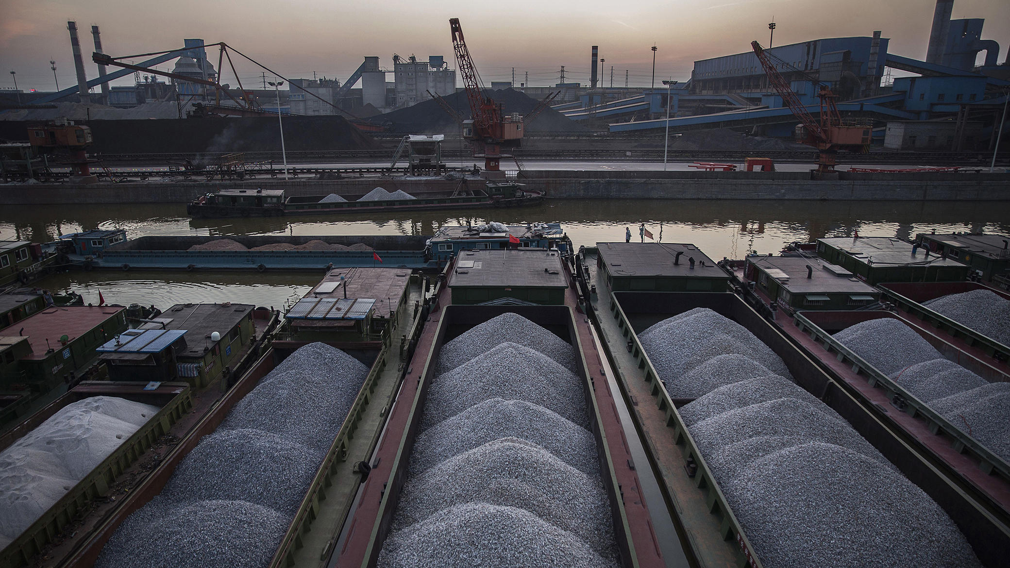 CHANGZHOU, CHINA - MAY 12:  Ore to be used in the manufacturing of steel is seen on barges in the Beijing-Hangzhou Canal in the logistics area of the Zhong Tian (Zenith) Steel Group Corporation on May 12, 2016 in Changzhou, Jiangsu. Zhong Tian (Zenith) Steel Group Corporation is a privately-owned manufacturer that employs over 13,000 workers at its facility in China's eastern Jiangsu province. Since 2001, the company says it has adopted new technology to streamline the production of premium quality steel and to reduce environmental impact. The majority of its steel output is for the Chinese market with 20% earmarked for export, mostly to Asia. The company says it is profitable, but admits business has dropped marginally from past years. China is the world's largest steel producer, accounting for over 50% of global supply. China's government has vowed to cut production capacity at state-owned enterprises by up to 150 million tonnes over five years to ease concerns of an oversupply on global markets. However, its efforts appear to be overshadowed by a recent increase in steel prices that has revived production at some Chinese facilities that had been closed down.  (Photo by Kevin Frayer/Getty Images)