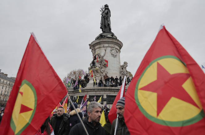 Kurdish activist holding Kurdistan Workers Party, PKK, flag stage a protest against the recent shooting at the Kurdish culture center next to the Republique square statue at in Paris, Saturday, Dec. 24, 2022. Kurdish activists, left-wing politicians and anti-racism groups are holding a protest Saturday in Paris after three people were killed at a Kurdish cultural center in an attack aimed at foreigners.(AP Photo/Lewis Joly)