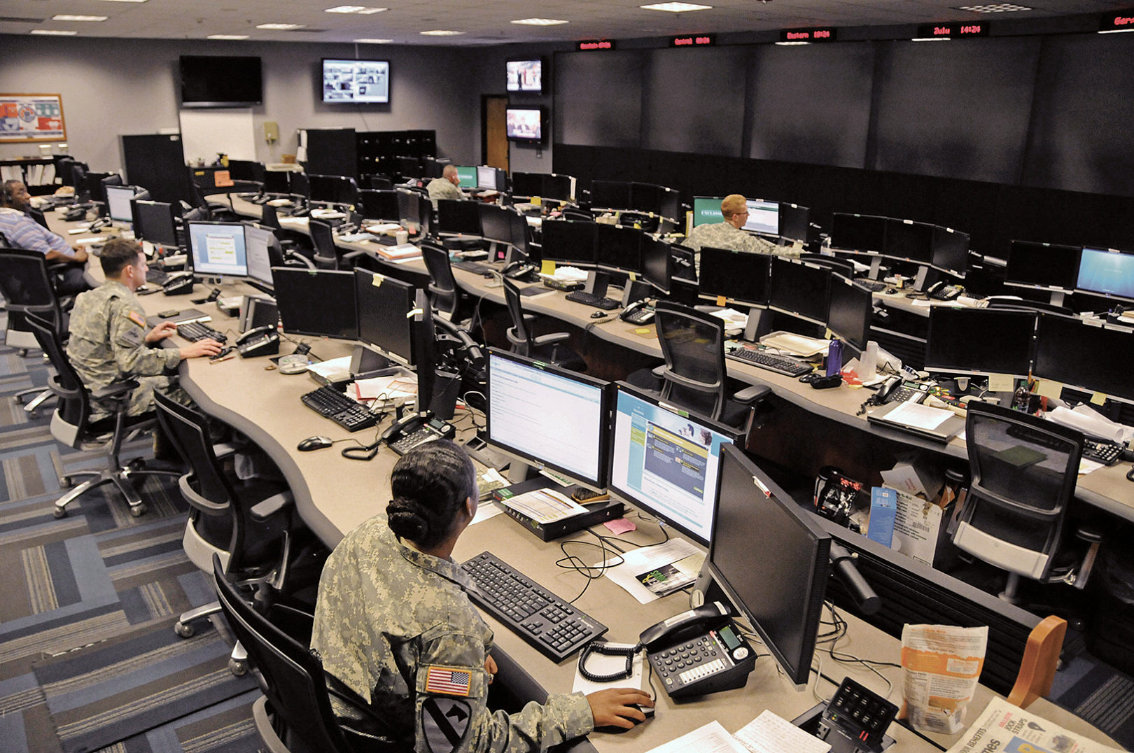 Uniformed and civilian cyber and military intelligence specialists monitor Army networks in the Cyber Mission Unit’s Cyber Operations Center at Fort Gordon, Ga. (Photo by Michael L. Lewis)