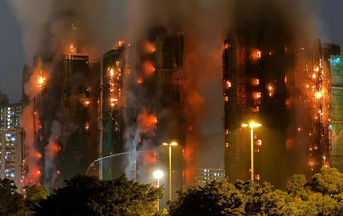 Thick smoke and flames rise as a major fire engulfs several apartment blocks at the Wang Fuk Court residential estate in Hong Kong's Tai Po district on November 26, 2025. At least four people were killed when a fire engulfed several high-rise blocks in a Hong Kong residential estate on November 26, the government said, with media reporting that some residents were trapped inside. (Photo by Yan ZHAO / AFP)