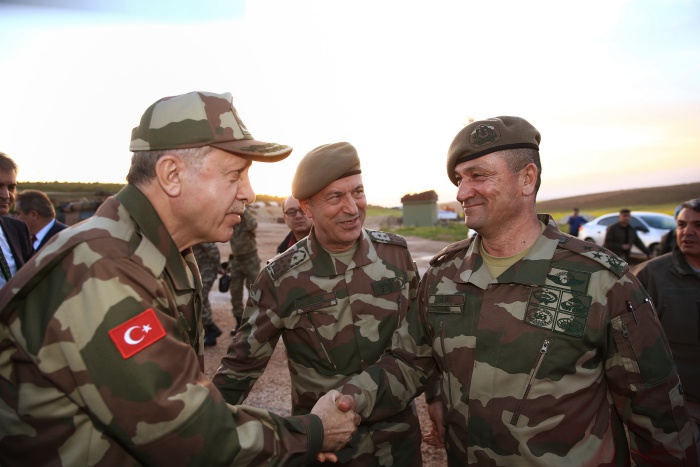 This handout picture taken and released by the Turkish Presidential Press Service on April 1, 2018 in Hatay shows Turkish President Recep Tayyip Erdogan, wearing a military camouflage uniform (L) shaking hands with Turkish Second Army Commander, Ismail Metin Temel (R) as Chief of the General Staff of the Turkish Armed Forces, Hulusi Akar (C) looks on during Erdogan's visit to border units in Turkey's Hatay province.  / AFP PHOTO / TURKISH PRESIDENTIAL PRESS SERVICE / KAYHAN OZER / RESTRICTED TO EDITORIAL USE - MANDATORY CREDIT "AFP PHOTO / TURKISH PRESIDENTIAL PRESS SERVICE / KAYAN OZER" - NO MARKETING NO ADVERTISING CAMPAIGNS - DISTRIBUTED AS A SERVICE TO CLIENTS