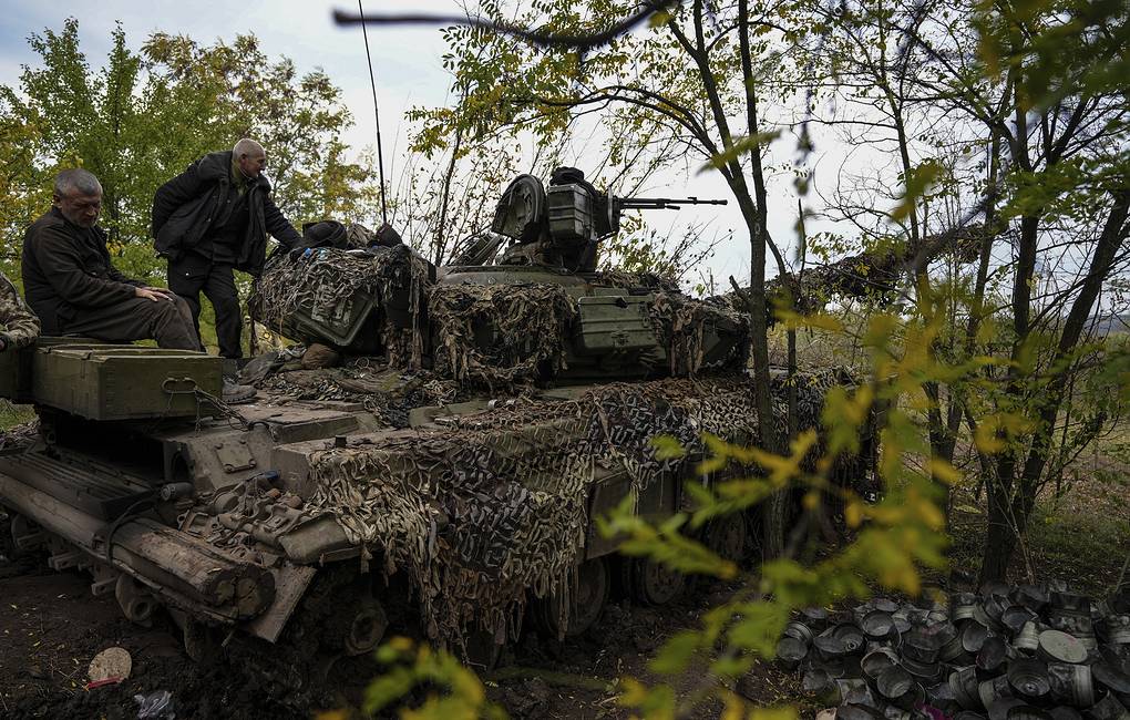Ukrainian servicemen stand on Ukrainian Soviet-made T-64 tank, in Bakhmut, Ukraine, Sunday, Oct. 2, 2022. (AP Photo/Inna Varenytsia)