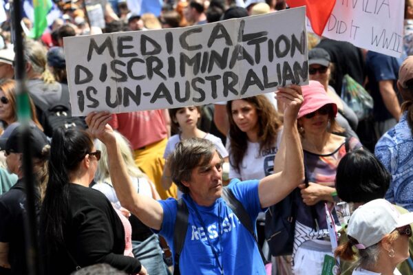A protester holds up a placard during a rally against new pandemic laws and vaccination mandates in Melbourne on December 4, 2021. (Photo by William WEST / AFP) (Photo by WILLIAM WEST/AFP via Getty Images)
